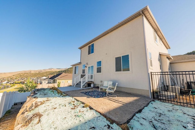 7390 N Pawnee Rd, Eagle Mountain, UT 84005 - rear view of property with a patio, a mountain view, and stucco siding
