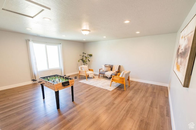 7390 N Pawnee Rd, Eagle Mountain, UT 84005 - playroom featuring light wood-style floors, a textured ceiling, recessed lighting, and attic access