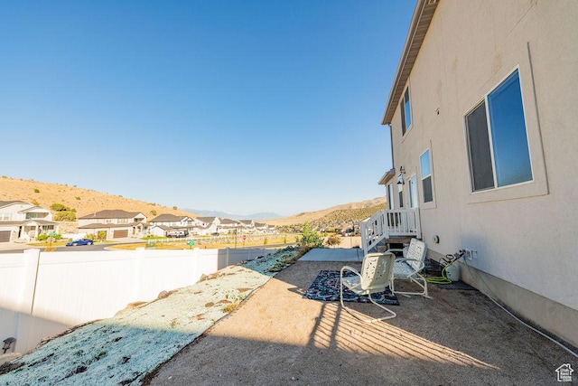 7390 N Pawnee Rd, Eagle Mountain, UT 84005 - fenced backyard featuring a mountain view, a patio, and a residential view