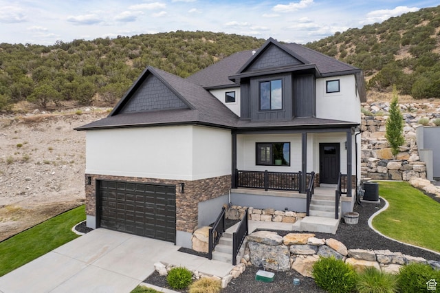 3873 E S Pass Cv, Eagle Mountain, UT 84005 - craftsman-style home featuring stone siding, covered porch, driveway, a garage, and a forest view