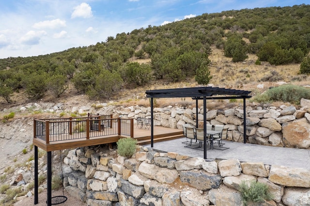3873 E S Pass Cv, Eagle Mountain, UT 84005 - view of patio / terrace featuring a wooden deck, a pergola, outdoor dining space, and a forest view
