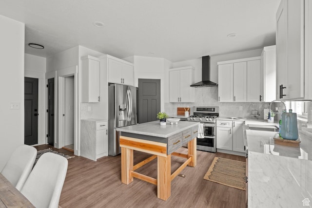 3873 E S Pass Cv, Eagle Mountain, UT 84005 - kitchen with wall chimney range hood, stainless steel appliances, white cabinets, and decorative backsplash