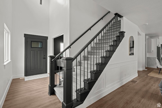 3873 E S Pass Cv, Eagle Mountain, UT 84005 - foyer entrance with stairs, wood finished floors, healthy amount of natural light, and a towering ceiling