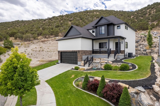 3873 E S Pass Cv, Eagle Mountain, UT 84005 - view of front of house with driveway, stone siding, a porch, and a front lawn