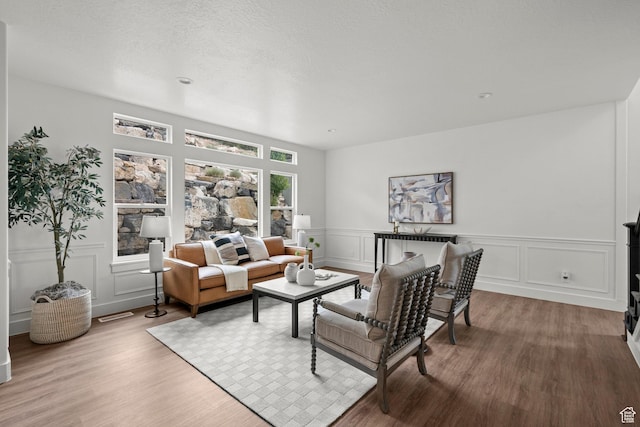 3873 E S Pass Cv, Eagle Mountain, UT 84005 - living area with wood finished floors, a decorative wall, and wainscoting