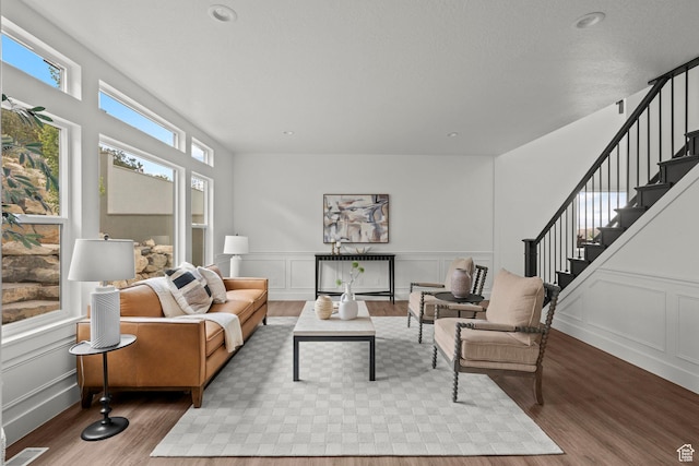 3873 E S Pass Cv, Eagle Mountain, UT 84005 - living area with wood finished floors, a decorative wall, stairs, and a wainscoted wall