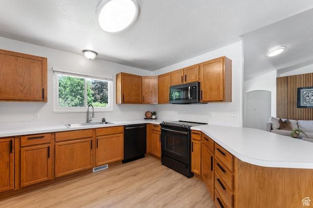 4974 W Diamondback Dr, Riverton, UT 84096 - kitchen with black appliances, a peninsula, light wood-style flooring, and light countertops