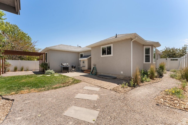 4974 W Diamondback Dr, Riverton, UT 84096 - back of property with a patio, a fenced backyard, and stucco siding