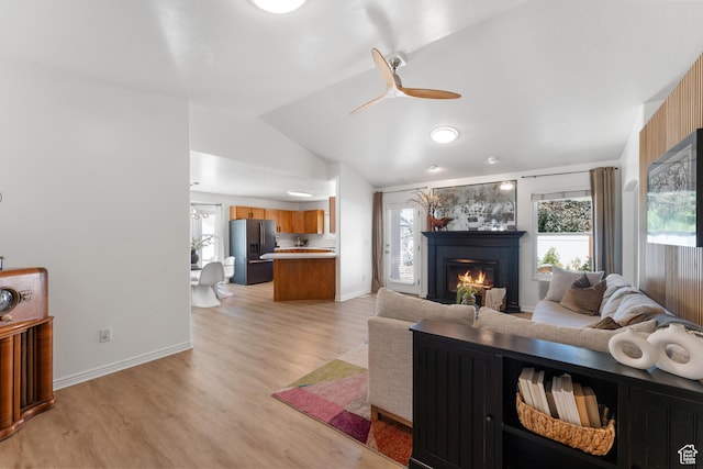 4974 W Diamondback Dr, Riverton, UT 84096 - living room featuring lofted ceiling, a tiled fireplace, light wood-type flooring, and ceiling fan