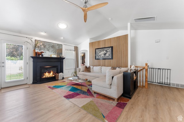 4974 W Diamondback Dr, Riverton, UT 84096 - living area with vaulted ceiling, wood finished floors, ceiling fan, arched walkways, and a glass covered fireplace
