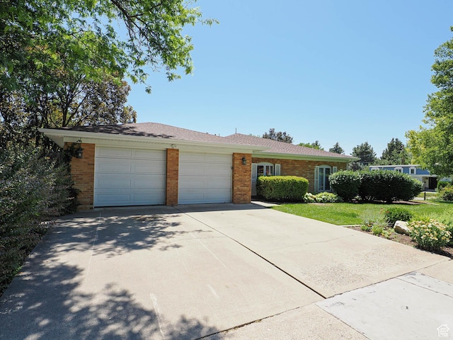 4893 S Regency St, Holladay, UT 84117 - ranch-style house featuring brick siding, an attached garage, and driveway