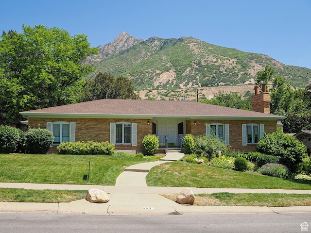 4893 S Regency St, Holladay, UT 84117 - ranch-style home featuring a chimney, a front lawn, brick siding, and a mountain view