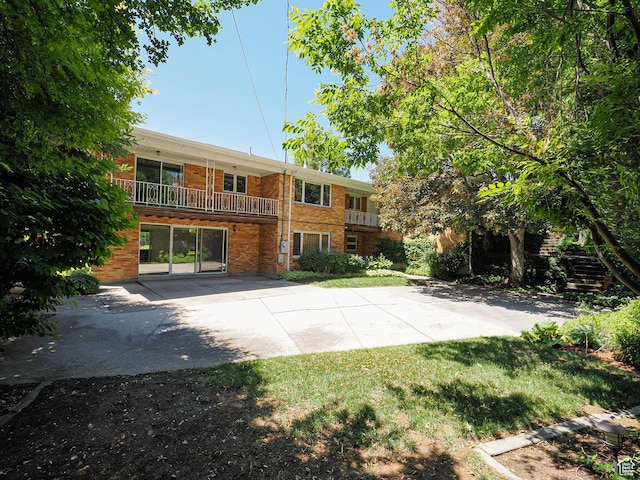 4893 S Regency St, Holladay, UT 84117 - back of house with brick siding and a yard