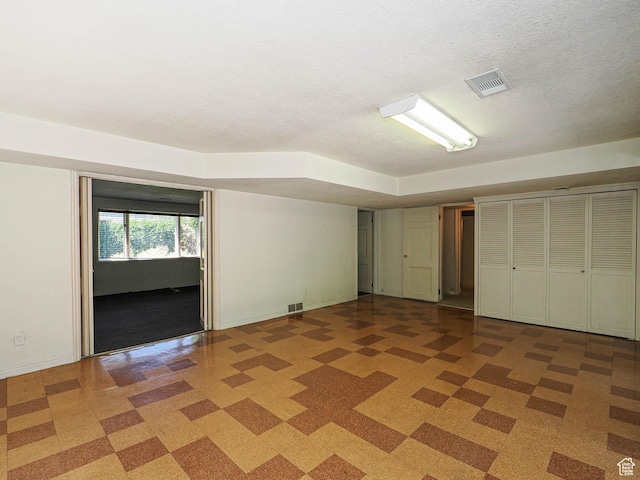 4893 S Regency St, Holladay, UT 84117 - unfurnished bedroom with light flooring, a textured ceiling, and two closets