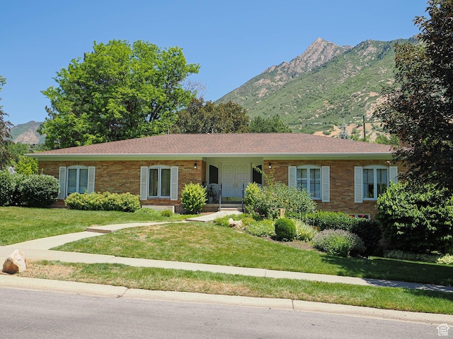 4893 S Regency St, Holladay, UT 84117 - ranch-style home with a mountain view, brick siding, and a front lawn