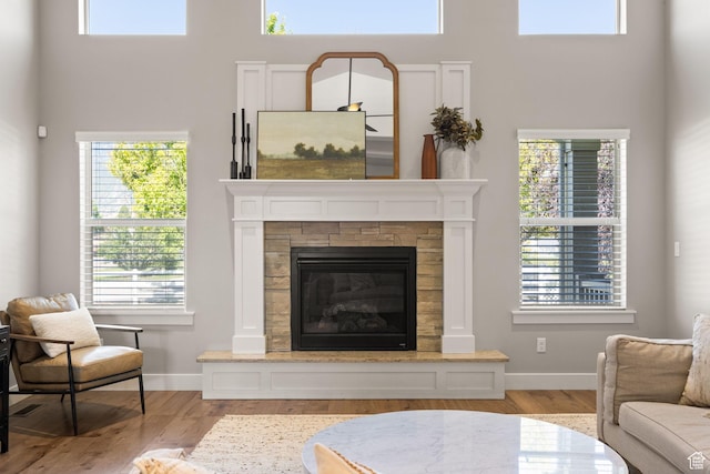 13571 S Meadow Heights Ln, Draper, UT 84020 - living area featuring wood finished floors, a stone fireplace, healthy amount of natural light, and a towering ceiling