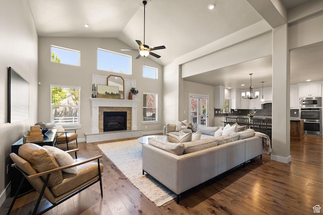 13571 S Meadow Heights Ln, Draper, UT 84020 - living room featuring a tiled fireplace, dark wood-type flooring, a ceiling fan, a chandelier, and high vaulted ceiling