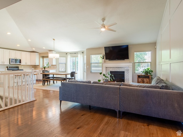 552 E Sunset Stream Way, Draper, UT 84020 - living room featuring vaulted ceiling, healthy amount of natural light, wood finished floors, a ceiling fan, and a fireplace