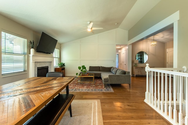 552 E Sunset Stream Way, Draper, UT 84020 - living area with lofted ceiling, a ceiling fan, a fireplace, a decorative wall, and wood finished floors