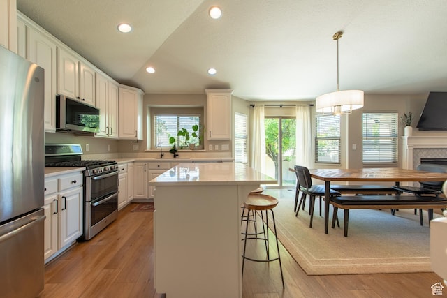 552 E Sunset Stream Way, Draper, UT 84020 - kitchen featuring stainless steel appliances, a kitchen bar, recessed lighting, light wood-style floors, and a kitchen island