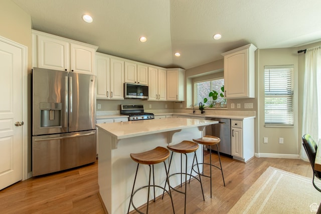 552 E Sunset Stream Way, Draper, UT 84020 - kitchen with stainless steel appliances, a kitchen breakfast bar, white cabinetry, a kitchen island, and light countertops