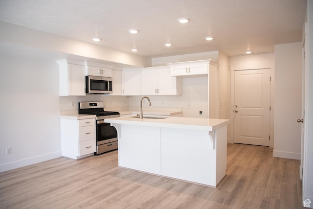 1362 N 1810 E, Spanish Fork, UT 84660 - kitchen with appliances with stainless steel finishes, light wood-type flooring, a center island with sink, white cabinetry, and light countertops