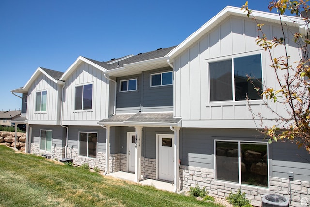 1362 N 1810 E, Spanish Fork, UT 84660 - view of front facade featuring board and batten siding, a front lawn, stone siding, and roof with shingles