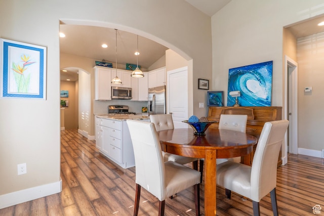 10296 S Salmon Dr, South Jordan, UT 84095 - dining room featuring arched walkways, wood finished floors, recessed lighting, and vaulted ceiling