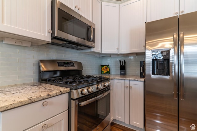 10296 S Salmon Dr, South Jordan, UT 84095 - kitchen featuring appliances with stainless steel finishes, backsplash, white cabinetry, and light stone countertops