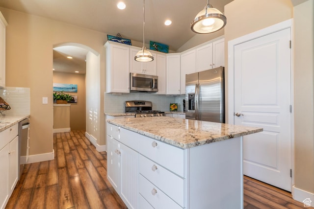 10296 S Salmon Dr, South Jordan, UT 84095 - kitchen with appliances with stainless steel finishes, arched walkways, a kitchen island, backsplash, and dark wood-style floors