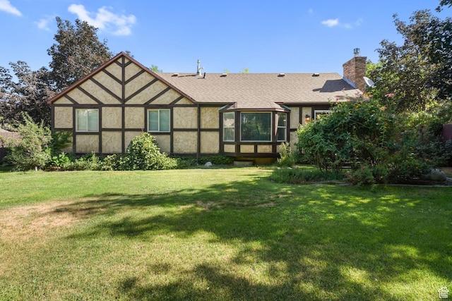 8916 S Cobble Crest Ln E, Sandy, UT 84093 - back of property with a lawn, a chimney, stucco siding, and a shingled roof