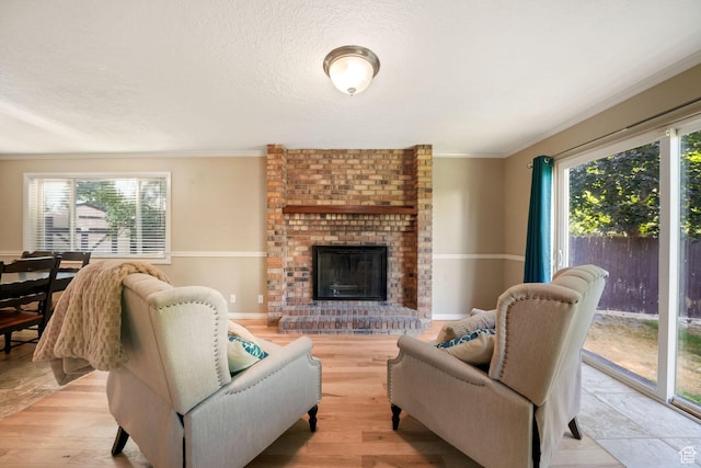 8916 S Cobble Crest Ln E, Sandy, UT 84093 - living room featuring ornamental molding, light wood finished floors, a brick fireplace, and a textured ceiling