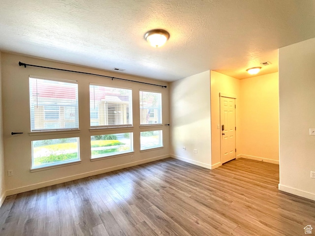 3794 W Angelica Ct, South Jordan, UT 84095 - unfurnished room with wood finished floors, plenty of natural light, and a textured ceiling