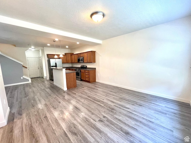 3794 W Angelica Ct, South Jordan, UT 84095 - kitchen with appliances with stainless steel finishes, open floor plan, wood finished floors, a kitchen island, and a textured ceiling