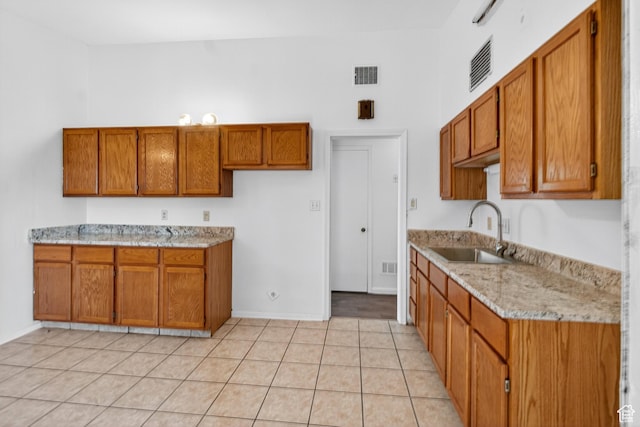 945 N 1200 W, Salt Lake City, UT 84116 - kitchen featuring brown cabinets, light tile patterned floors, light stone countertops, and a towering ceiling