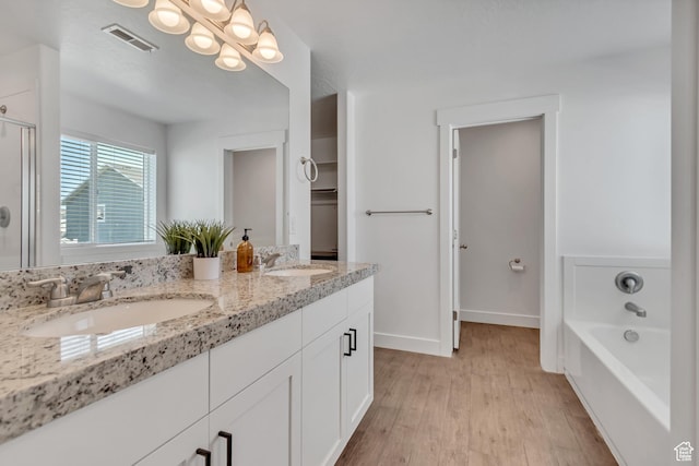4913 E Golden Meadow Xing, Eagle Mountain, UT 84005 - bathroom with double vanity, wood finished floors, a bathtub, and a shower with door