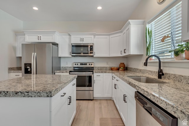 4913 E Golden Meadow Xing, Eagle Mountain, UT 84005 - kitchen featuring stainless steel appliances, recessed lighting, white cabinetry, light stone counters, and a kitchen island