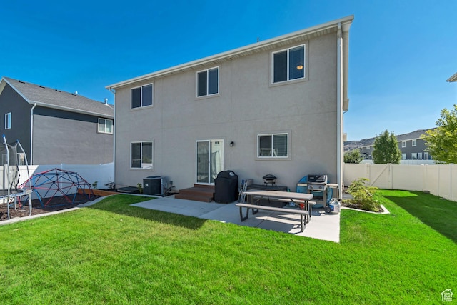 4913 E Golden Meadow Xing, Eagle Mountain, UT 84005 - back of property featuring a trampoline, a patio area, a fenced backyard, and stucco siding