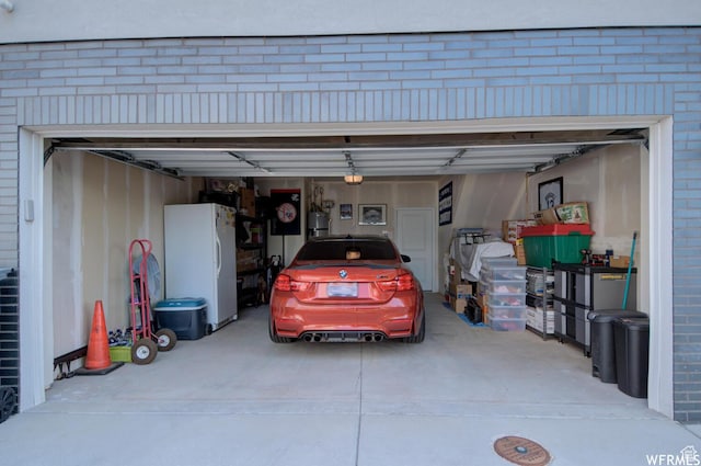 1690 S 225 W, Clearfield, UT 84015 - garage featuring freestanding refrigerator, driveway, and a garage door opener