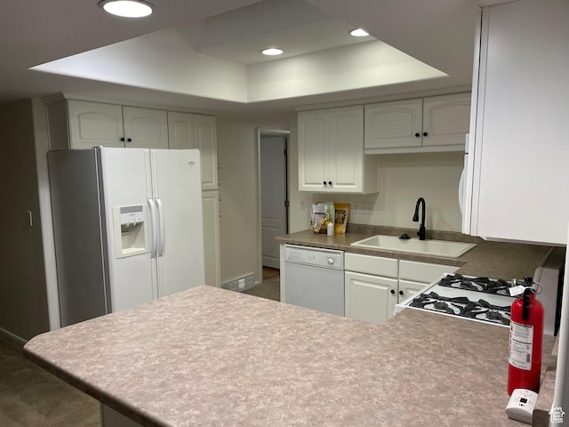 484 N 300 W, Logan, UT 84321 - kitchen featuring white appliances, a raised ceiling, a peninsula, recessed lighting, and white cabinetry