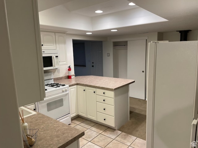484 N 300 W, Logan, UT 84321 - kitchen with white appliances, a tray ceiling, a peninsula, recessed lighting, and light tile patterned floors