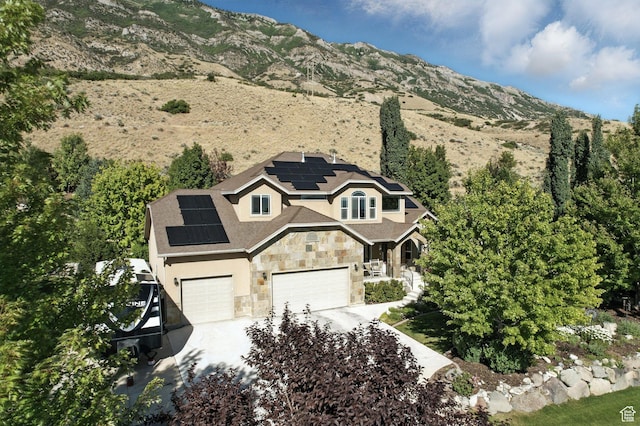 9116 Silver Lake Dr, Cedar Hills, UT 84062 - view of front of house featuring stone siding, roof mounted solar panels, a garage, driveway, and stucco siding