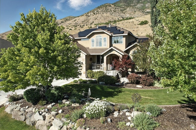 9116 Silver Lake Dr, Cedar Hills, UT 84062 - view of front of home featuring covered porch, roof mounted solar panels, a front yard, and stucco siding