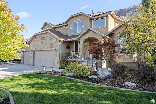 9116 Silver Lake Dr, Cedar Hills, UT 84062 - view of front of house with stone siding, stucco siding, solar panels, driveway, and covered porch