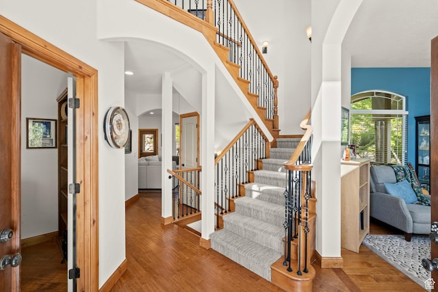 9116 Silver Lake Dr, Cedar Hills, UT 84062 - stairs with wood finished floors, arched walkways, a towering ceiling, and recessed lighting