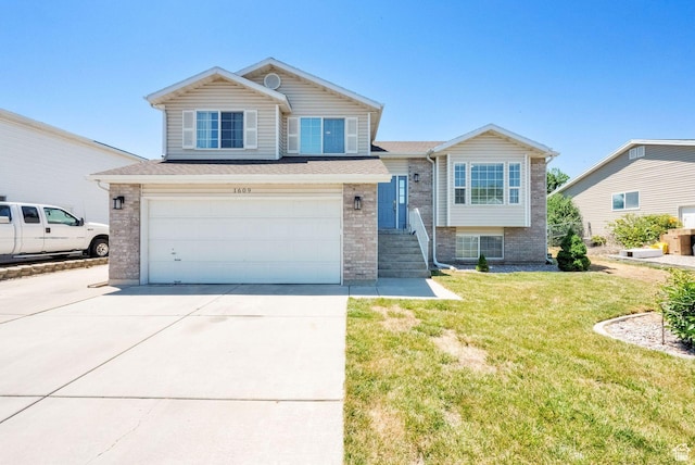 1609 N 2275 W, Clinton, UT 84015 - split level home with driveway, an attached garage, brick siding, a front lawn, and a shingled roof