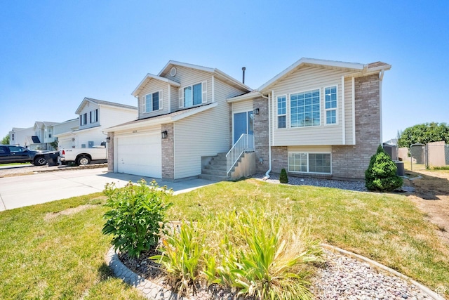 1609 N 2275 W, Clinton, UT 84015 - tri-level home with brick siding, concrete driveway, a garage, and a front yard