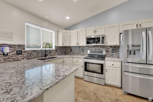 1609 N 2275 W, Clinton, UT 84015 - kitchen featuring appliances with stainless steel finishes, lofted ceiling, tasteful backsplash, light stone countertops, and white cabinets