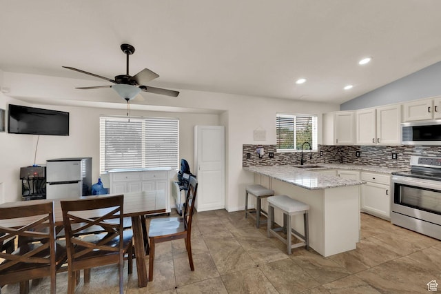 1609 N 2275 W, Clinton, UT 84015 - kitchen featuring stainless steel appliances, a peninsula, white cabinets, decorative backsplash, and light stone counters