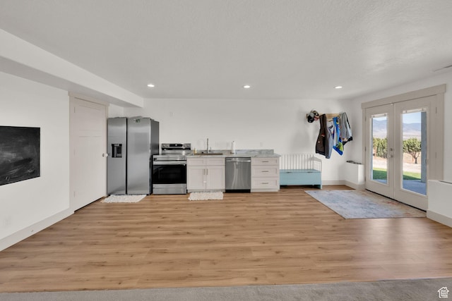 2423 W Cedarline Loop, Stockton, UT 84071 - kitchen with appliances with stainless steel finishes, light wood-style flooring, white cabinets, light countertops, and french doors